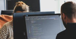Two software developers working at computer monitors in an office